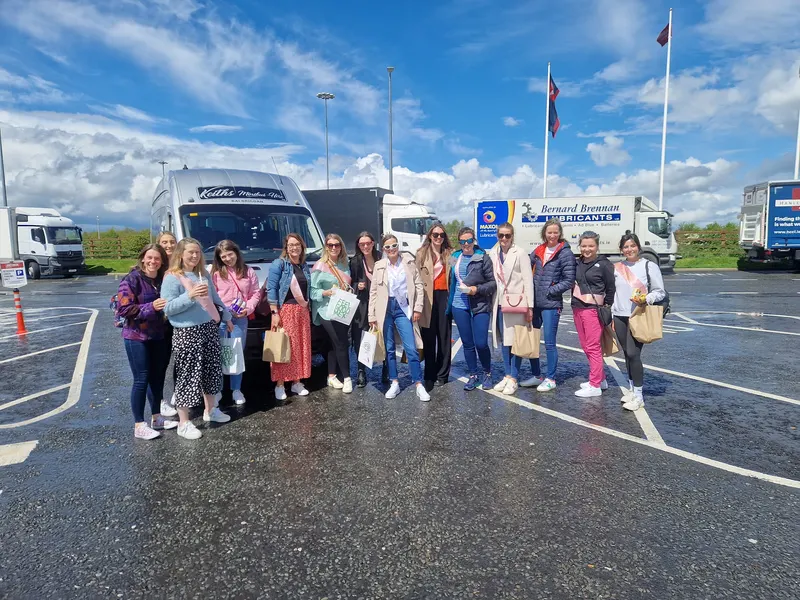 Group standing beside coaches in a car park