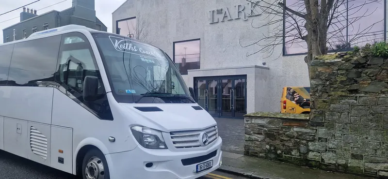 White mini coach parked outside a building