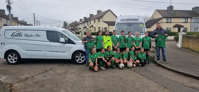 Sports team standing beside a minibus
